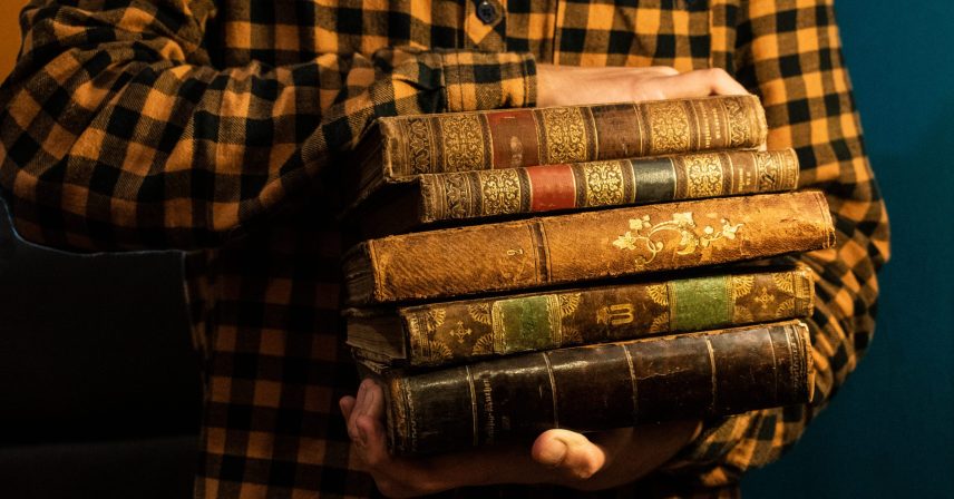 Young man is reading old books.